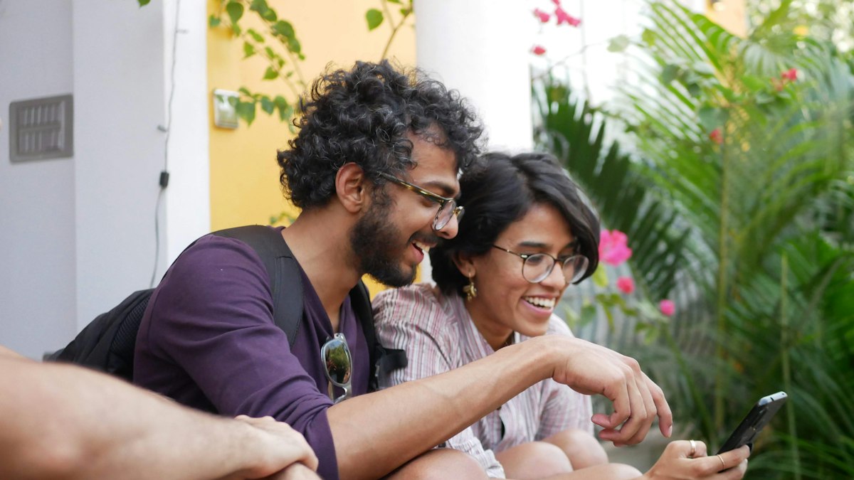 A young couple laughing while looking at a smartphone outdoors in India | Diwali 2026