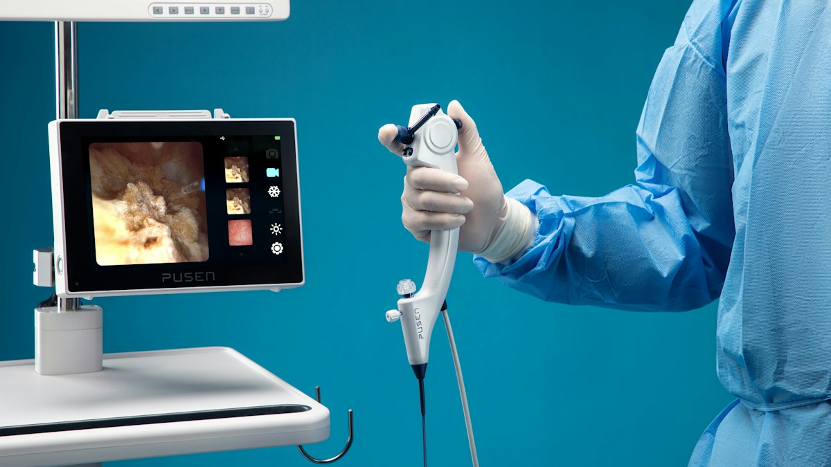 A clinician in surgical gown holding an endoscope beside a monitor showing an internal image | Diwali 2026