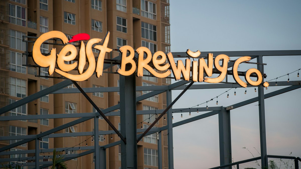 Illuminated brand sign of a brewery in Bengaluru against tall apartment buildings | Diwali 2026