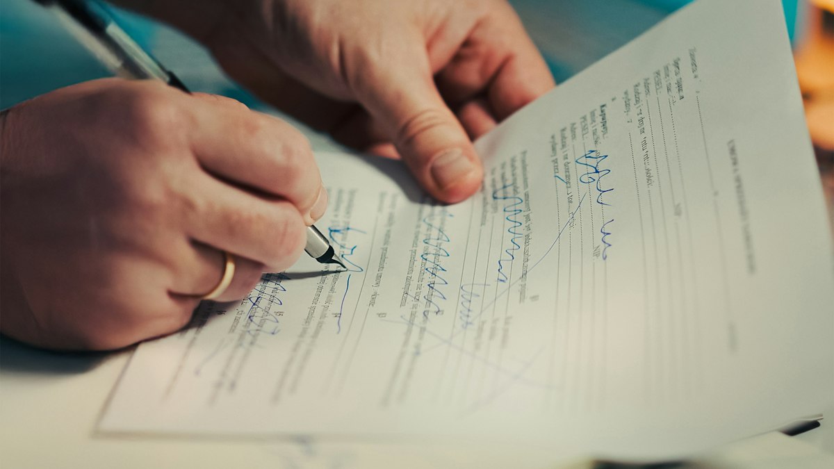 A hand signing a printed company document with a fountain pen | Diwali 2026